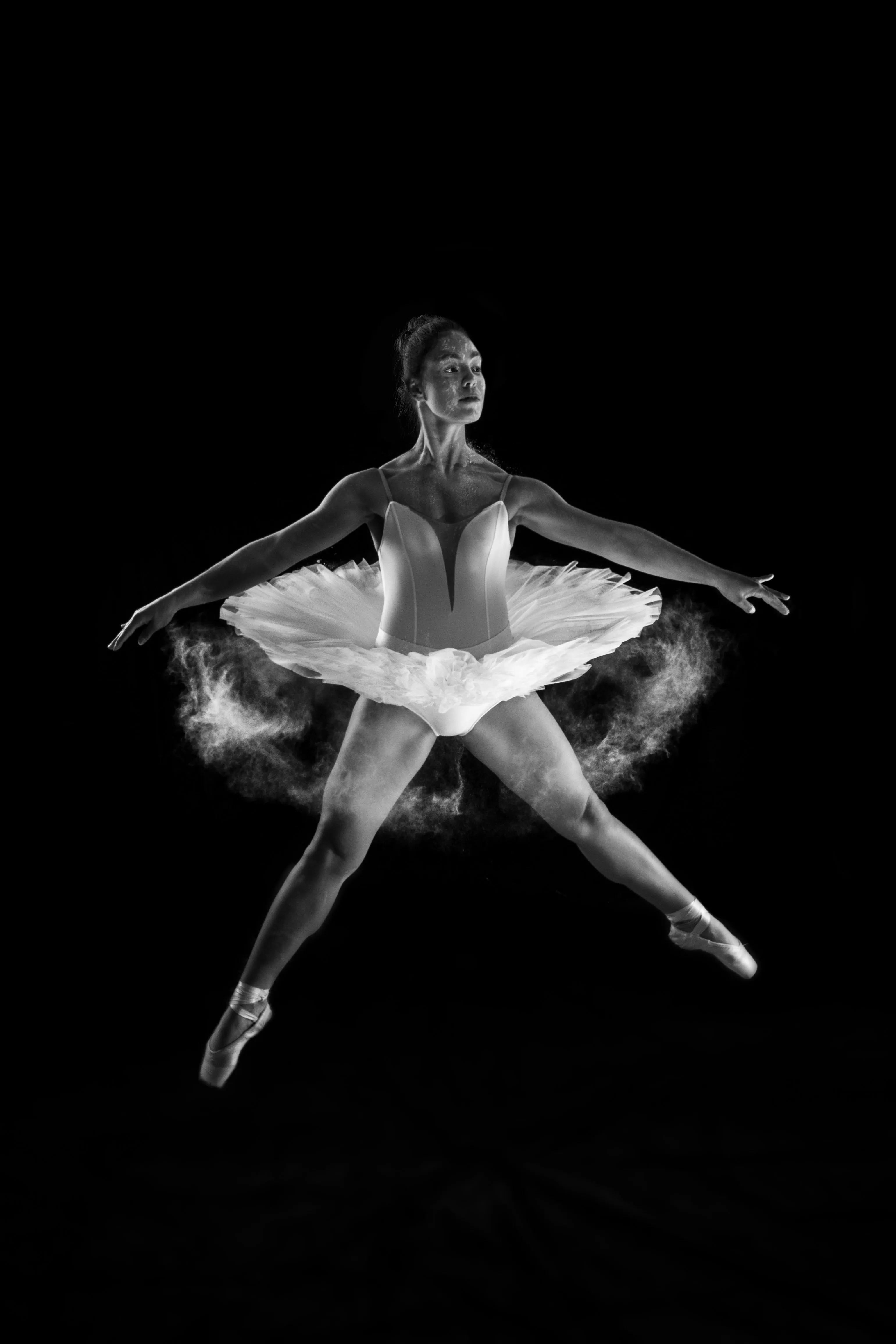 Malena Ríos en un salto, tutú clásico, sobre fondo oscuro